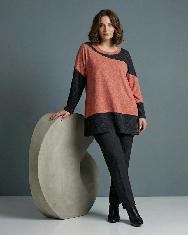 Асиметрична зимна туника в корал и графит за голям размер, представена в цял ръст върху модел с видим диагонален дизайн и декоративни копчета.