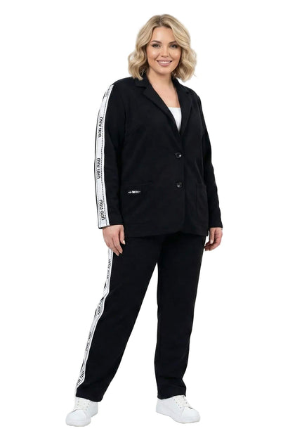 Черен ежедневен дамски комплект от сако и панталон големи размери, декориран с бели ленти с надписи по страничните ръбове, представен в цял ръст.