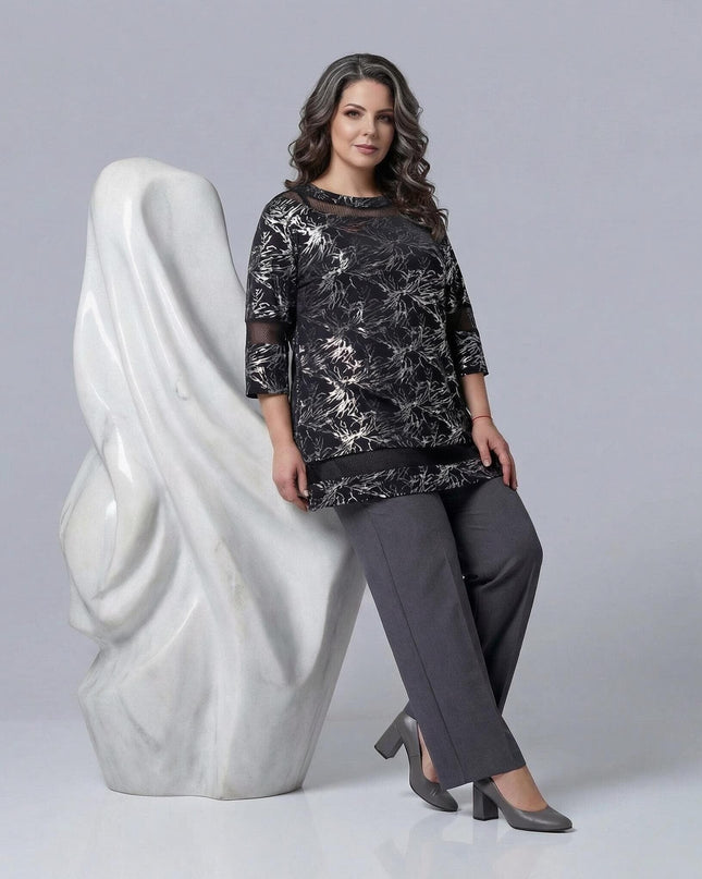 Черна официална макси туника със сребрист принт и мрежести детайли. Моделът е показан в цял ръст, комбинирал туниката със сив панталон.
