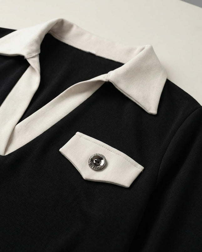 Детайл отблизо на черна официална макси рокля с контрастна бяла яка, дълбоко V-образно деколте и декоративно джобче с метално копче.