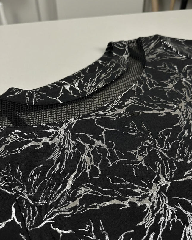 Плосък кадър детайл отблизо на черна официална макси туника, акцентиращ върху мрежестото деколте и сребристия принт.