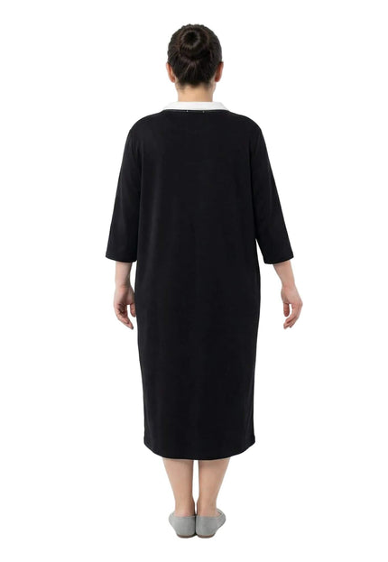 Черна спортно-елегантна макси рокля с права кройка, снимана отзад в цял ръст, показваща изчистен силует и бял детайл на яката.