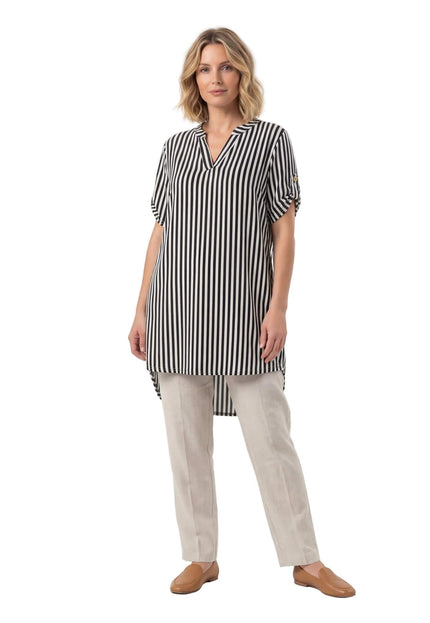 Дамска дълга туника с черно-бяло райе, V-образно деколте и асиметричен подгъв. Представена в цял ръст на бял фон, съчетана със светъл панталон.