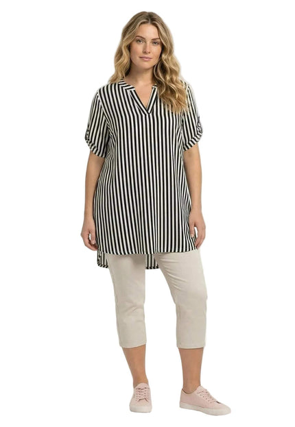 Дамска дълга памучна туника големи размери с черно-бяло райе, цял ръст, V-образно деколте, асиметричен подгъв, на бял фон.