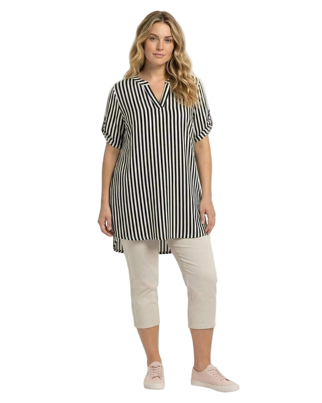 Дамска дълга памучна туника големи размери с черно-бяло райе, цял ръст, V-образно деколте, асиметричен подгъв, на бял фон.