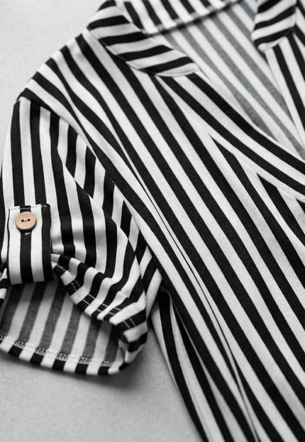 Детайл отблизо на дамска дълга памучна туника големи размери, показващ ръкав с декоративно копче и черно-бяло райе.