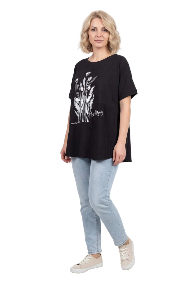 Дамска лятна макси туника с цветя и дантела в черен цвят. Разкроен силует с паднало рамо. Снимана в цял ръст на бял фон.