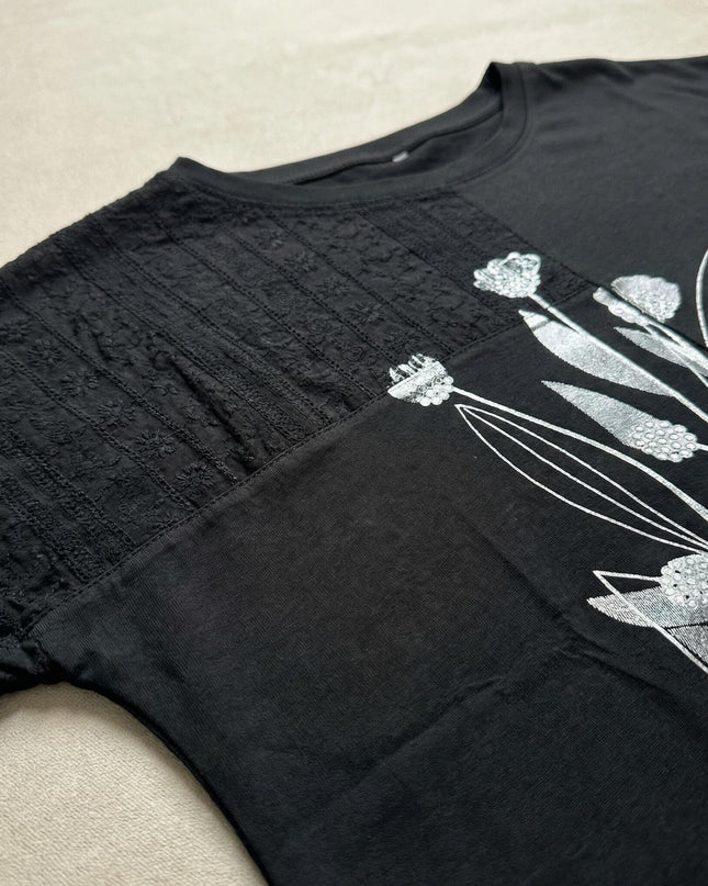 Детайл отблизо на дамска лятна макси туника с цветя и дантела в черен цвят. Плосък кадър на горната част.