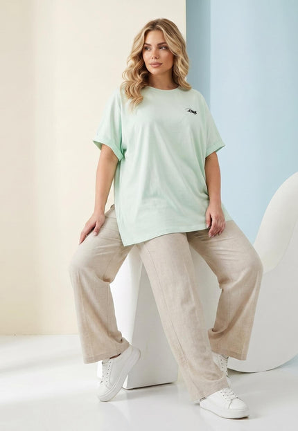Светла резедава памучна макси тениска с щампа, показана върху модел в цял ръст със свободна кройка.