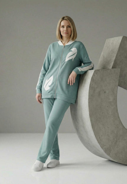 Дамски макси комплект от две части в светлозелено с бели детайли от еко кожа, представен в цял ръст до декоративна бетонна форма.