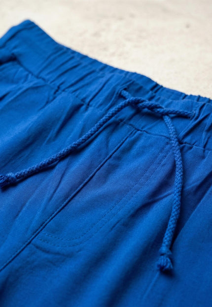 Детайл отблизо на еластичния колан с връзки на кралскосин дамски панталон големи размери.