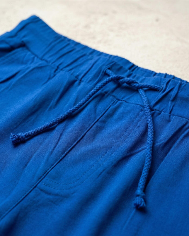 Детайл отблизо на еластичния колан с връзки на кралскосин дамски панталон големи размери.