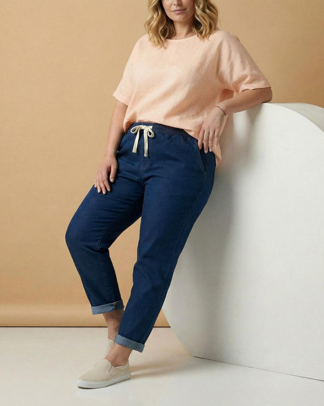 Дамски прави еластични дънки в син цвят с навит подгъв и ластична талия с връзки, показани в цял ръст върху модел.