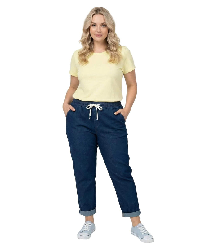 Цял ръст дамски прави еластични дънки в син цвят, модел с ластик и бяла връзка в талията, на бял фон.