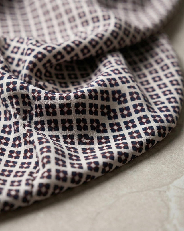 Детайл отблизо на материята на ефирна шифонена туника с геометричен принт в бежово и кафяво, показващ текстурата и гънките на плата.