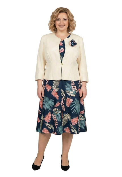 Елегантен дамски костюм големи размери, съчетаващ тъмносиня рокля с цветни мотиви и бежово сако, заснет в цял ръст.