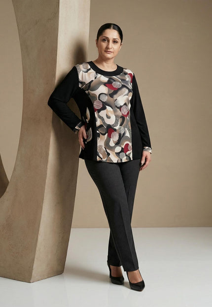 Елегантна черна туника с централен абстрактен принт в бежово и червено, заснета в цял ръст върху модел до декоративна колона.