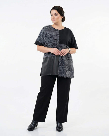 Елегантна черна туника в цял ръст, демонстрираща модерен дизайн с релефна мъхеста материя и долен панел от еко кожа.