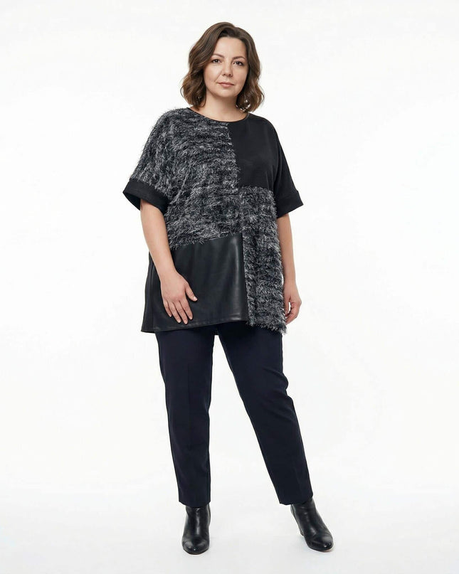 Елегантна черна туника с релефна мъхеста текстура и панел от еко кожа, представена в цял ръст. Модел с асиметричен дизайн и свободна кройка за макси дами.