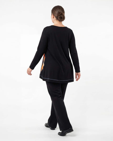 Елегантна есенна туника в черно, заснета отзад в цял ръст. Вижда се изчистеният гръб с централен шев, дългите ръкави и свободната кройка на модела.