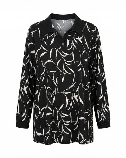 Елегантна дамска макси туника с абстрактен принт на листа в черно и бяло. Моделът е с черна яка, V-образно деколте и маншети, заснет фронтално на бял фон.