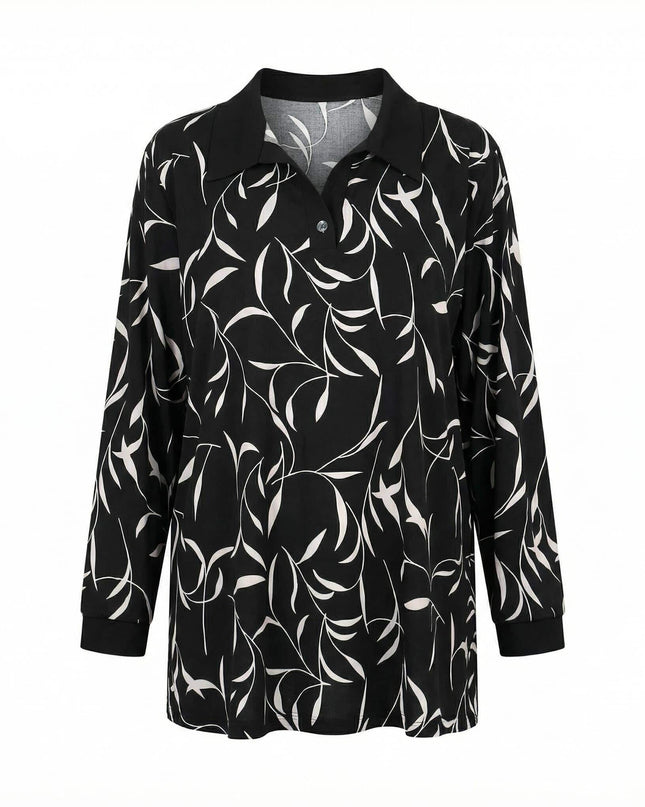 Елегантна дамска макси туника с абстрактен принт на листа в черно и бяло. Моделът е с черна яка, V-образно деколте и маншети, заснет фронтално на бял фон.