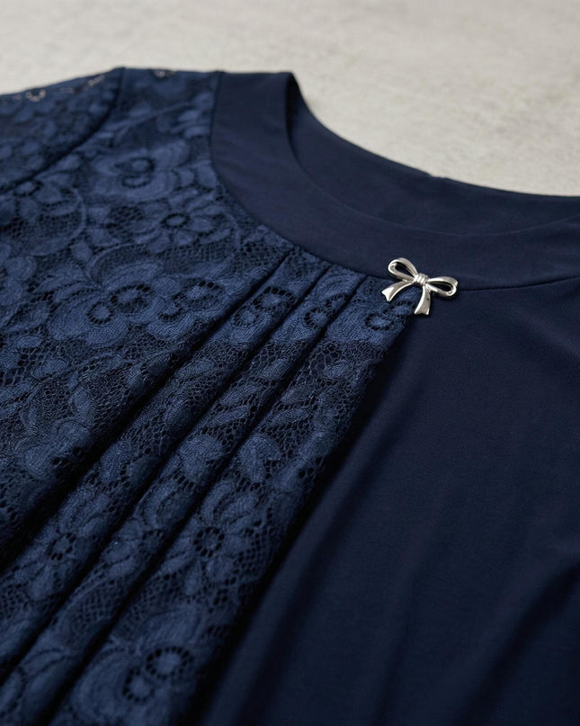 Детайлен кадър на елегантна макси туника в тъмносиньо, показващ дантеления панел с плисета и декоративна сребриста брошка на деколтето.