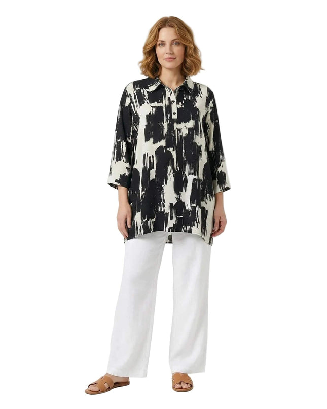 Официална макси риза в черно и бяло със свободен силует. Моделът е с ефектен абстрактен принт и класическа якичка. Цял ръст на бял фон.