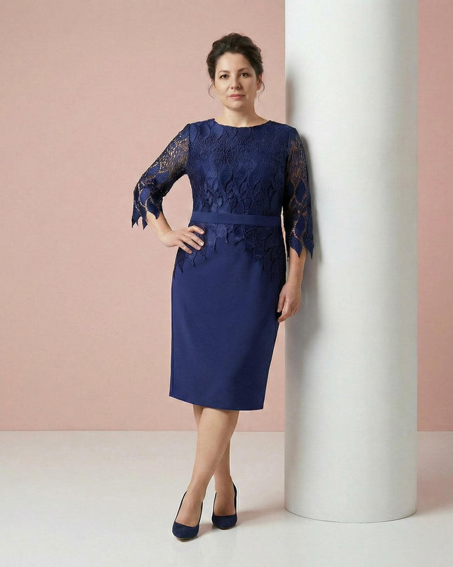 Елегантна тъмносиня макси рокля с дантелена горна част и колан, представена в цял ръст до бяла колона