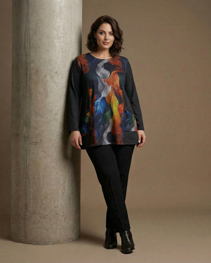 Елегантна туника с абстрактен принт Есенни листа и едноцветни страни, представена в цял ръст върху модел с черен панталон.