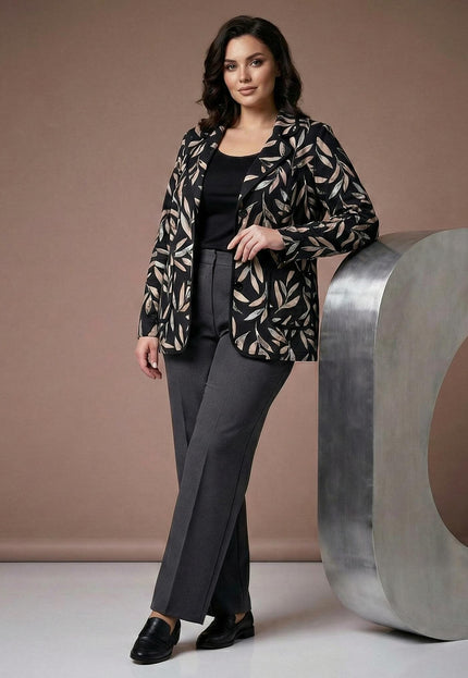 Елегантно черно макси сако с абстрактен десен на листа, представено в цял ръст върху модел до декоративен метален елемент.