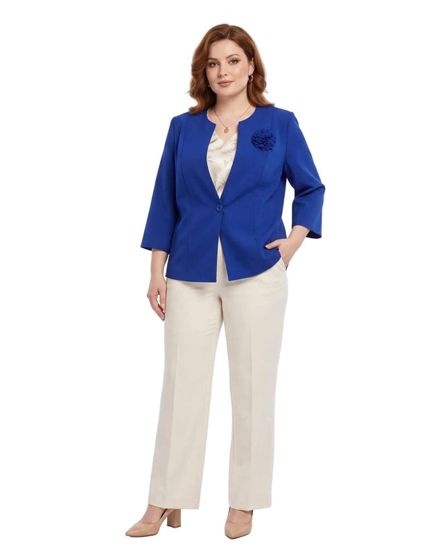 Елегантно дамско сако в кралскосин цвят с тричетвърт ръкави и подвижна роза, представено в цял ръст на бял фон в съчетание с панталон.