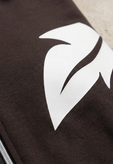 Детайл отблизо на бял принт във форма на листо и цип върху горнището на ежедневен дамски макси комплект в кафяво.