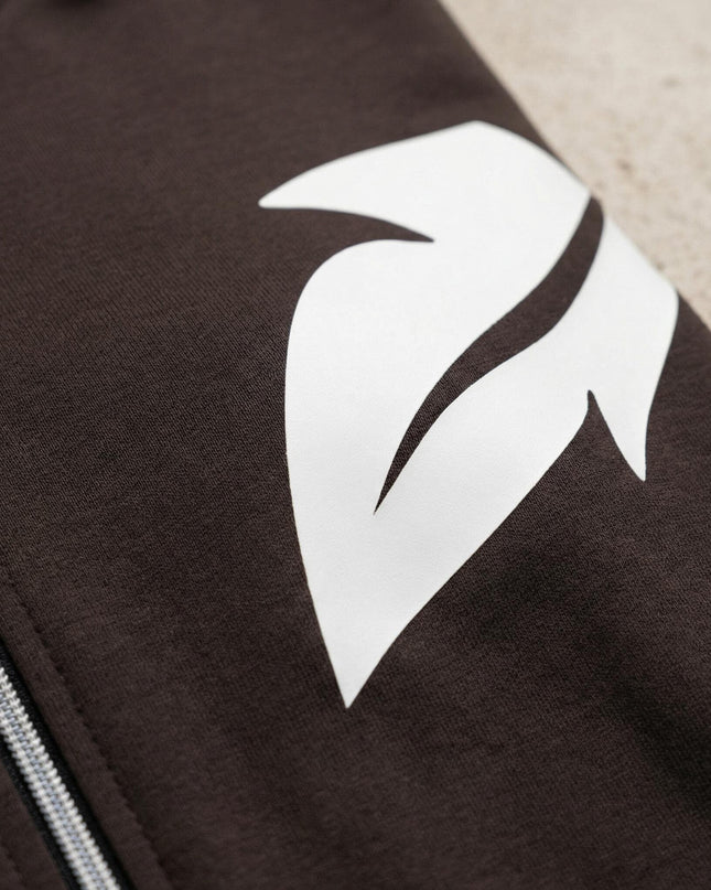 Детайл отблизо на бял принт във форма на листо и цип върху горнището на ежедневен дамски макси комплект в кафяво.