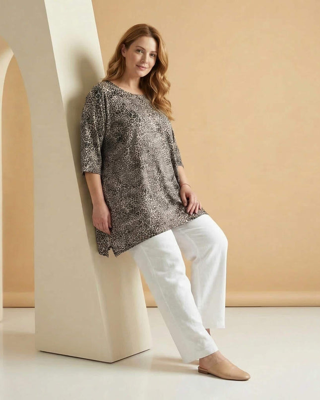 Ежедневна макси туника с леопардов десен и 3/4 ръкави, представена в кадър цял ръст върху модел, комбинирана с бели панталони.
