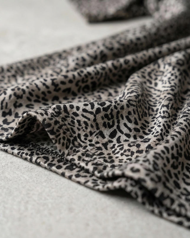 Детайл отблизо, показващ фината материя с класически леопардов десен и качествения шев на подгъва на дамска макси туника.