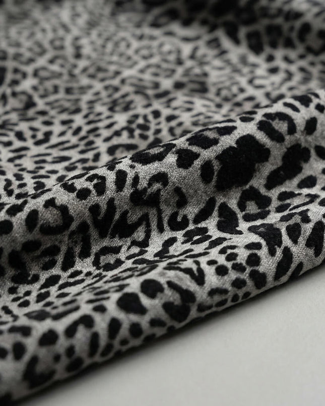 Детайл отблизо на материята на ежедневна макси туника, показващ ефектен леопардов десен в сиво и черно.