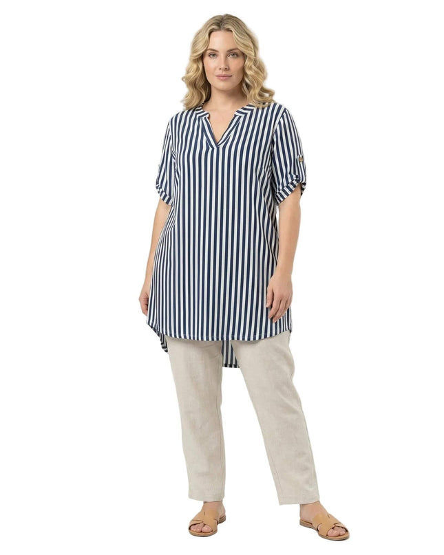 Дамска макси туника в бяло с тъмносиньо вертикално райе, V-образно деколте и асиметрична дължина, заснета в цял ръст на бял фон.