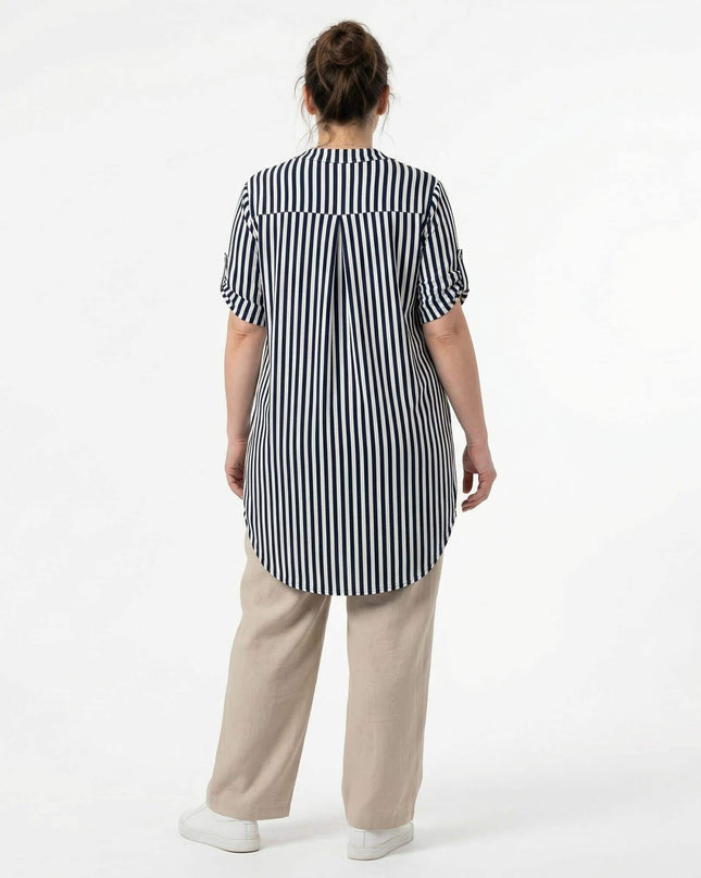 Изглед отзад на лятна дамска макси туника в бяло с тъмносиньо райе. Моделът показва удължената асиметрична задна част и платката с фалта на гърба.