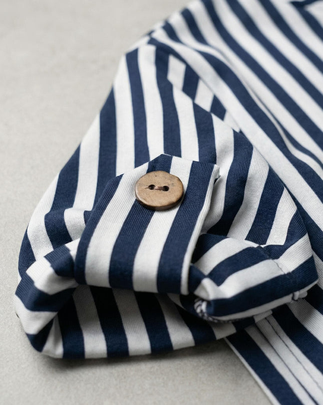 Детайл отблизо на ръкав с декоративна лента и копче от дамска макси туника в бяло с тъмносиньо райе.