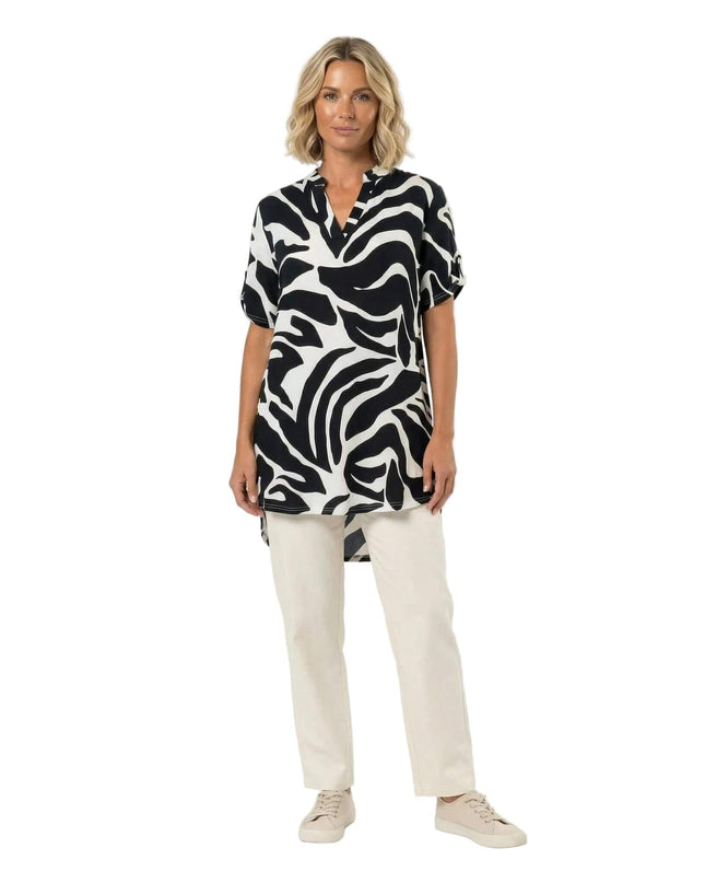 Макси лятна туника с черно-бял абстрактен принт, V-образно деколте и къси ръкави, представена в цял ръст на бял фон.