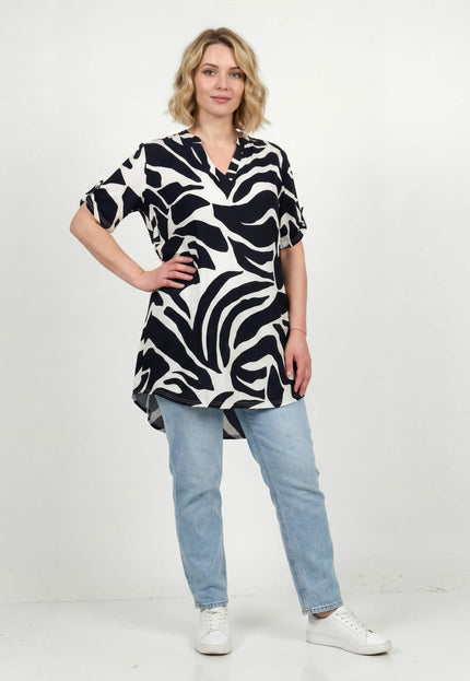 Жена, облечена в макси лятна туника с асиметрична кройка и абстрактен черно-бял принт, представена в цял ръст.