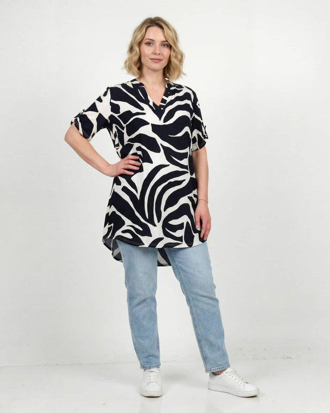 Жена, облечена в макси лятна туника с асиметрична кройка и абстрактен черно-бял принт, представена в цял ръст.