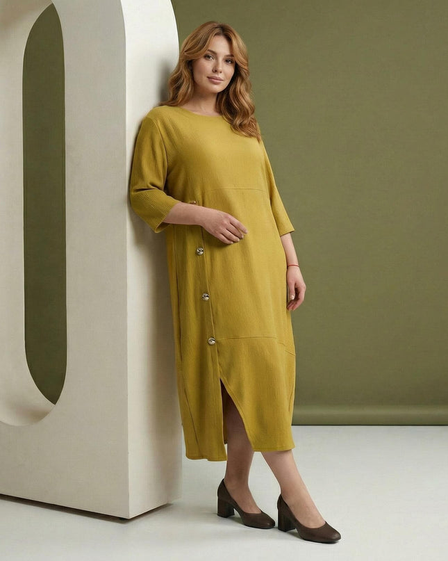 Дамска макси официална рокля в цвят горчица, с 3/4 ръкави и асиметрични декоративни копчета, заснета в цял ръст.