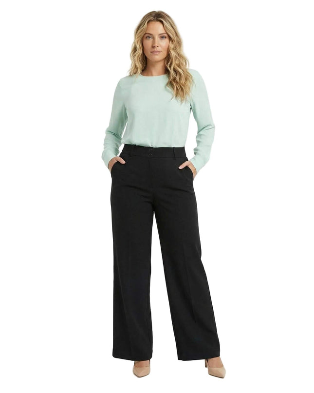 Студийна снимка в цял ръст на официален черен панталон големи размери с права кройка, съчетан със светлозелена блуза и бежови обувки на висок ток.