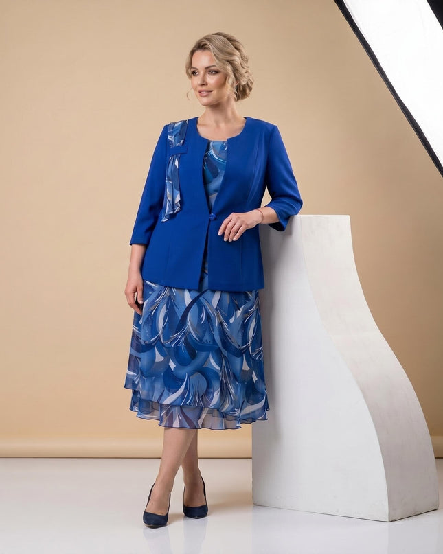 Дамски официален костюм от две части в кралскосин цвят - елегантно сако и разкроена шифонена рокля с принт, заснет в цял ръст.