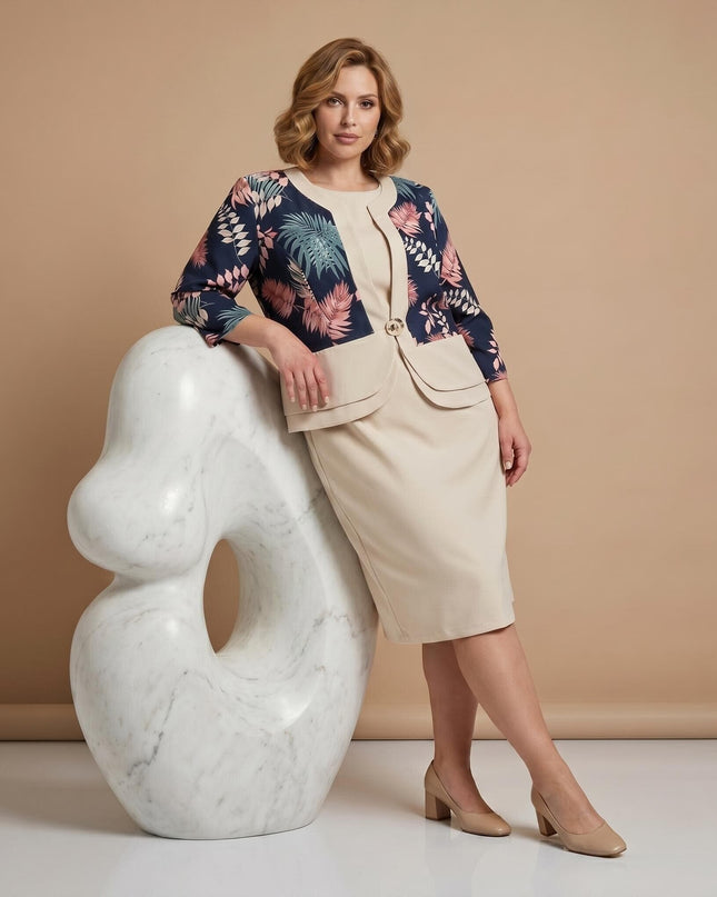 Елегантен официален комплект големи размери с бежова рокля и флорално сако, представен в цял ръст върху модел до бяла скулптура.
