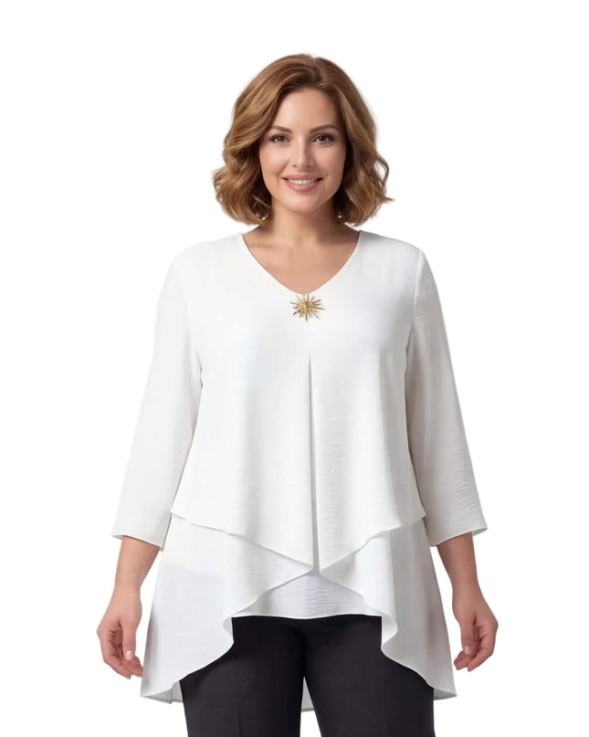 Официална бяла макси туника с асиметрична кройка на пластове, 7/8 ръкави и златна брошка на деколтето, заснета отпред.