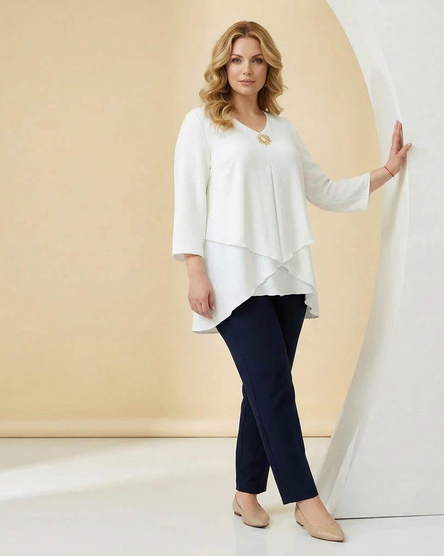 Официална бяла макси туника с асиметрична кройка и брошка, кадър в цял ръст.