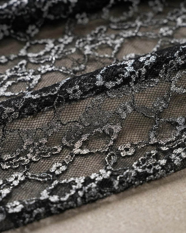 Детайл отблизо на фината флорална дантела с бляскави нишки, част от елегантната официална черна макси рокля.